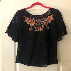 Darling Boutique Blu Pepper Black Lace Floral Embroidery Top Size Small S Grosgrain Ribbon Tie In Back Flutter Double Lace Sleeves 70% Cotton 30% Nylon Measure Armpit To Armpit 18 Inches Neckline To Hem 20 Inches Gorgeous Versatile Top Elegant Black Tops With Floral Embroidery, Black Summer Tops With Intricate Embroidery, Lace Blouse With Floral Embroidery, Black Embroidered Tops For Summer, Black Top With Intricate Embroidery, Black Tops With Intricate Embroidery For Summer, Elegant Black Embroidered Summer Top, Embroidered Short Sleeve Lace Blouse, Short Sleeve Embroidered Lace Blouse