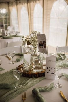 the table is set with flowers in glass vases