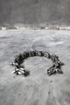 Snake vertebrae cast in metal, set between punk spikes. Made with a unique flexible design, this bracelet can flex to contour around your wrist.This unisex piece fits between a 6.5" on the tightest setting and 8" on the loosest setting.If you need a different size range, specify when ordering. Punk Style Silver Bracelet With Studs, Punk Style Silver Jewelry With Silver Studs, Silver Punk Bracelets With Studs, Edgy Silver Stud Jewelry, Gothic Metal Bracelet With Studs, Adjustable Metal Punk Bracelets, Punk Style Silver Bangle Bracelet, Silver Edgy Bracelets For Streetwear, Gothic Silver Jewelry With Studs