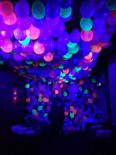 balloons are lit up in the dark for a party