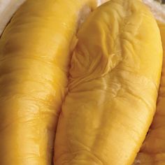 two large yellow bananas sitting next to each other on a white tablecloth covered surface