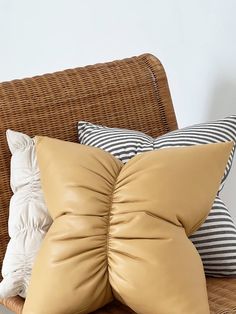 two tan pillows sitting on top of a wicker couch