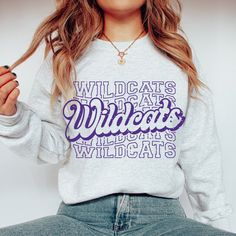 "Title: \"Show Off Your Wildcat Pride with a Customized Sweatshirt - Perfect for College Sports Fans!\" Description: Are you a new college student, proud parent of a college student, graduating college student, or a college sports fan? Look no further than our Wildcats sweatshirt! This Gildan 18000 sweatshirt is available in a variety of colors, including black, white, ash, sport grey, sand, and purple.  Crafted from a comfortable blend of 50% cotton and 50% polyester, this unisex sweatshirt is Varsity Sweatshirt, School Spirit Shirts, High School Sports, University Sweatshirts, Football Sweatshirt, Spirit Shirts, College Sweatshirt, Style Sweatshirt, Spirit Wear