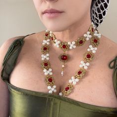 This stunning necklace set, inspired by the Renaissance era, and a portrait of Catherine Howard, is a true work of art. The intricate design features pearls, metal cabochons, and resin gemstones adding a unique and striking touch to any outfit. Crafted by hand, this necklace set is a piece that is sure to impress. With its elegant style and variety of color options , it is perfect for any outfit from Queen to commoner. Add this necklace set to your collection today and make a statement at your n Costume Gold Metal Jewelry, Elegant Gold Costume Jewelry, Elegant Gold Jewelry For Costume, Elegant Handmade Costume Jewelry, Catherine Howard, Tudor Gown, Tudor Style, Queen Mary, Stunning Necklace