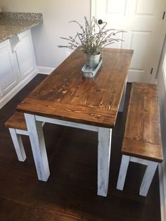 a wooden table with two benches next to it on a hard wood floor in a kitchen