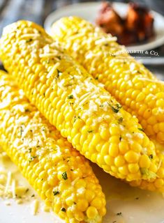 grilled corn on the cob with parmesan cheese and herbs, ready to eat