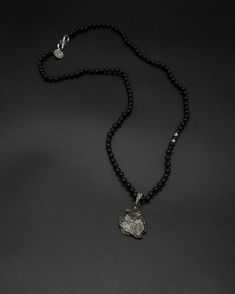 Add a touch of cosmic beauty to your collection with this Campo del Cielo meteorite pendant on a hand-knotted onyx and silver accented chain. The onyx chain is 59 cm long [app 23 in long] Black Amulet Necklace With Natural Stones, Black Amulet Necklace With Polished Beads, Black Amulet Necklaces With Polished Beads, Black Amulet Style Necklaces With Polished Beads, Black Amulet Necklace With Large Pendant, Obsidian Pendant Amulet Necklace, Obsidian Amulet Pendant Necklace, Silver Obsidian Necklaces, Silver Obsidian Necklace With Natural Stones