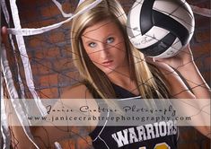 a beautiful young woman holding a volleyball in front of a net with the words warrior written on it