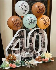 a table topped with balloons and a sign that says 40 years ago, surrounded by other balloons