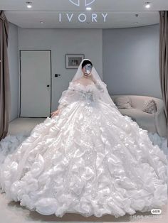 a woman in a white wedding dress is posing for the camera