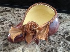 a decorative vase sitting on top of a marble counter next to a wooden flower pot