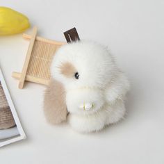 a white stuffed animal sitting on top of a table next to a wooden comb and banana