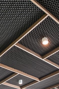 the ceiling is covered with metal mesh panels and a light bulb in the middle of it