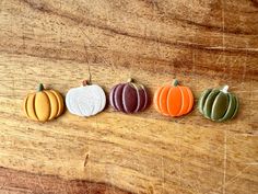 four small pumpkins sitting on top of a wooden table