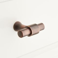 an image of a door handle on the side of a white cabinet with wood handles