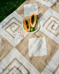 two pieces of papaya on a plate and some diced up cards are sitting on the grass