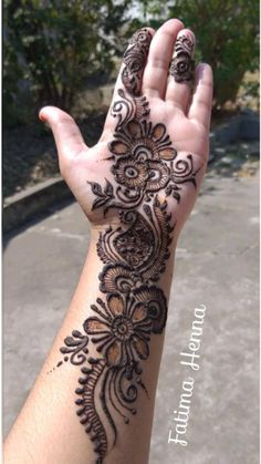 a woman's hand with henna tattoos on it