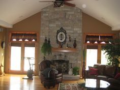 a living room with couches, chairs and a fireplace