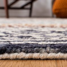 an area rug on the floor with a chair in the background