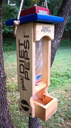 a wooden bird feeder hanging from a tree