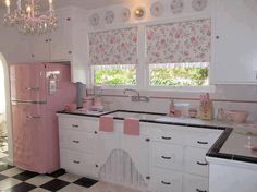 a pink refrigerator freezer sitting inside of a kitchen