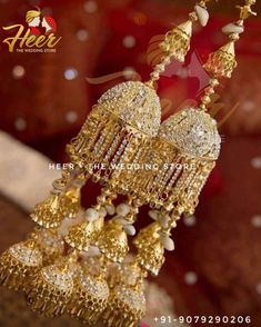 the gold earrings are adorned with pearls and beads