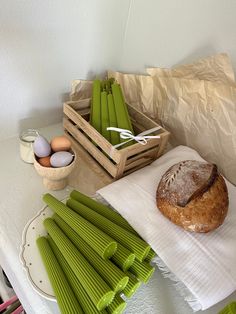 bread, green asparagus and eggs on a white tablecloth with paper napkins