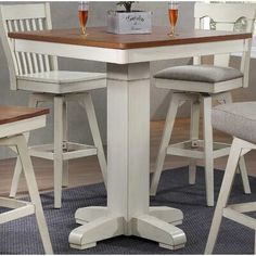 a kitchen table with four stools and a potted plant