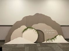 a couple of large white sculptures sitting on top of a wooden floor next to a wall