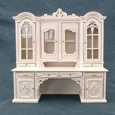 a doll house desk with white furniture and drawers