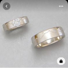 two gold wedding bands with a diamond in the center