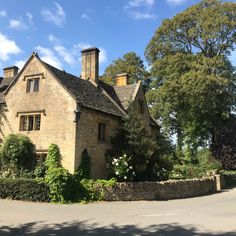 an old stone house surrounded by greenery and trees