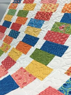 a multicolored quilt is on display