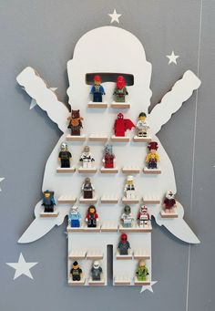 a christmas tree made out of legos is hanging on the wall with white stars