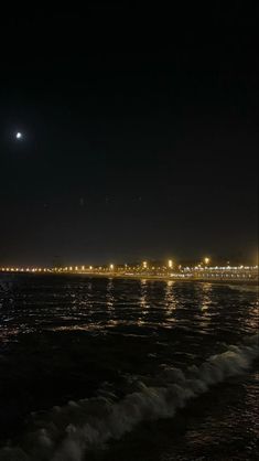 the moon shines brightly in the night sky over the ocean