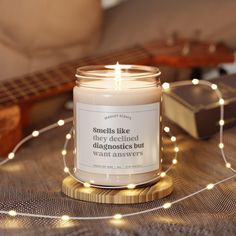 a candle sitting on top of a table next to a string of lights and a guitar