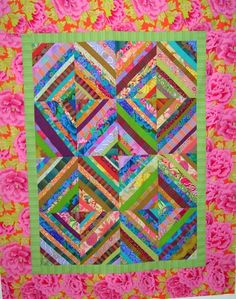 a pink and green quilt with flowers on it