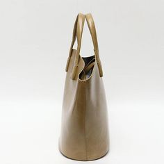 Discover Everyday Elegance Step into the world of sophistication with our Elegant Vegan Leather Tote Bag, a perfect blend of style and functionality. Crafted for the modern woman, this bag is not just an accessory; it's a statement. Whether you're heading to work, a casual outing, or a special event, this tote bag will elevate your style with its simple yet chic design. Product Features Our tote bag stands out with its unique bucket shape, offering a fresh take on the classic tote design. The blend of short handles and long straps provides versatile carrying options, catering to your comfort and preference. Made from high-quality vegan leather, this bag not only looks luxurious but also aligns with ethical fashion choices. The open closure with a secure zip liner bag ensures your belonging Beige Double Handle Box Bag With Dust Bag, Beige Double Handle Bag With Dust Bag, Beige Double Handle Bags With Dust Bag, Cream Bucket Bag With Removable Pouch For On-the-go, Luxury Beige Shoulder Bag For On-the-go, Luxury Beige Hobo Bag With Dust Bag, Modern Bucket Bag With Leather Handles For On-the-go, Beige Top Handle Box Bag For On-the-go, Modern Bucket Bags For On-the-go