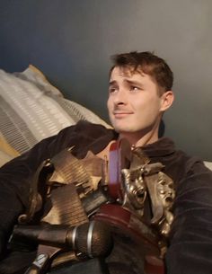 a man sitting on top of a bed wearing armor