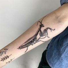 a man with a tattoo on his arm that has an image of a praying mantissa