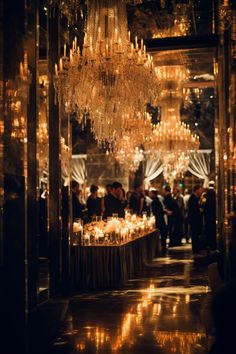 a large chandelier hanging from the ceiling in a room filled with tables and chairs