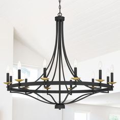 a chandelier hanging from the ceiling in a room with white walls and wood floors