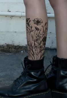 a woman's legs with tattoos and flowers on them