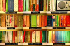 a book shelf filled with lots of books and electronic devices on top of each other