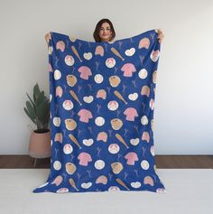 a woman holding up a blue blanket with ice cream and cupcakes on it