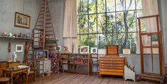 an old fashioned room with lots of furniture and decor on the walls, along with a large window