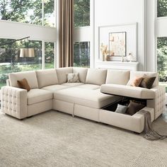 a living room with a sectional couch and coffee table in the center, surrounded by large windows