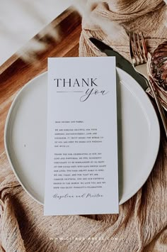 a white plate with a thank you card on it next to a fork and knife