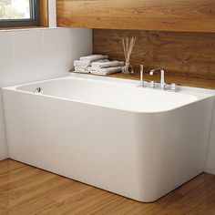 a white bath tub sitting on top of a wooden floor