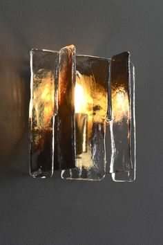 a light that is on the side of a wall with some kind of glass in it